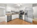 Bright kitchen boasts white cabinets, stainless steel appliances, and laminate flooring for a clean, modern look at 250 Dixon Rd, Graham, NC 27253