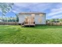 View of the home's rear exterior featuring a well-maintained lawn and wood fence at 2802 Bingham Dr, Mebane, NC 27302