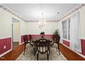 Traditional dining room with hardwood floors, chair rail, chandelier, and large windows at 3027 Maple # T1, Burlington, NC 27215