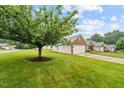 Spacious lawn surrounding brick-and-siding homes, showcasing a well-maintained community at 3027 Maple # T1, Burlington, NC 27215