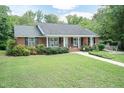 A single-story brick home with a convenient ramp and lush landscaping provides accessible living at 303 Spring St, Louisburg, NC 27549