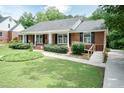 A single-story brick home with a convenient ramp and lush landscaping provides accessible living at 303 Spring St, Louisburg, NC 27549