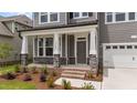 Inviting front porch featuring stone accents, white columns, brick steps, and well-manicured landscaping at 3500 Bailey Lake Dr, Fuquay Varina, NC 27526