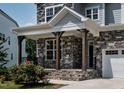 Inviting front porch with stone accents, wooden columns, and a charming black railing at 359 Abbot Pl, Chapel Hill, NC 27516