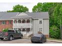 Two-story condo building with charming white porch and gray siding, plus two cars parked out front at 405 Gooseneck Dr # B6, Cary, NC 27513