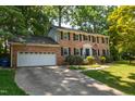 Charming two-story brick home with attached garage and a lush, landscaped front yard at 4200 Marvin Pl, Raleigh, NC 27609