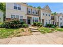Charming townhome featuring a well-manicured front yard, inviting entrance, and concrete steps leading to the front door at 4353 Sugarbend Way, Raleigh, NC 27606