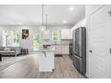Kitchen featuring stainless appliances, granite countertops, and white cabinetry open to living area at 445 Sturgeon St, Smithfield, NC 27577