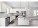Bright kitchen features stainless appliances, an island with granite countertops, and white cabinetry at 445 Sturgeon St, Smithfield, NC 27577