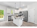 Bright kitchen features stainless appliances, an island with granite countertops, and white cabinetry at 445 Sturgeon St, Smithfield, NC 27577