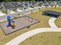Aerial view of community playground with slides, swings, picnic shelter, and paved walkways among the homes at 445 Sturgeon St, Smithfield, NC 27577