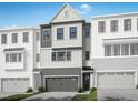 Charming townhome showcasing a well-manicured lawn, a two-car garage, and a covered front entryway at 4713 Mint Leaf Ln, Raleigh, NC 27612