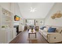 Comfortable living room featuring vaulted ceilings, a fireplace, built-ins, and ample natural light at 4805 Castle Crest Ct, Raleigh, NC 27616