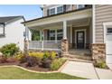 Charming covered front porch with stone accents and manicured landscaping at 525 Marion Hills Way, Knightdale, NC 27545