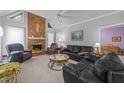 Comfortable living room with a cozy fireplace, plush seating, and natural light from the windows at 7605 Pats Branch Dr, Raleigh, NC 27612