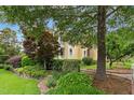 Manicured front yard showcasing lush landscaping around a yellow home, creating a picturesque and inviting curb appeal at 800 Highgrove Dr, Chapel Hill, NC 27516