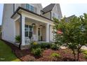 Inviting front porch with rocking chairs and lush landscaping creating a welcoming entrance at 857 Mill Station Ln, Wendell, NC 27591