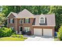 Attractive brick home with black shutters, arched windows, mature landscaping, and a two-car garage at 904 Oldwyck Dr, Fuquay Varina, NC 27526