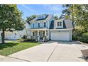 Charming two-story home with a welcoming front porch, well-maintained lawn, and a two-car garage at 908 Town Side Dr, Apex, NC 27502