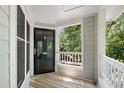 Open balcony featuring wood floors, gray walls, and white railings overlooking backyard greenery at 911 Washington St # 304, Raleigh, NC 27605