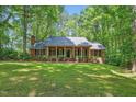 Charming brick home featuring a covered porch with stately columns and manicured landscaping at 9257 Sauls Rd, Raleigh, NC 27603