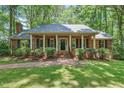 Charming brick home featuring a covered porch with stately columns and manicured landscaping at 9257 Sauls Rd, Raleigh, NC 27603