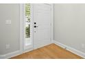 Clean, minimalist entryway with hardwood floors, white door and trim at 95113 Vance Knls, Chapel Hill, NC 27517