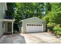 View of a detached two-car garage with white doors and an adjacent entry door at 1006 Apache Ln, Apex, NC 27502