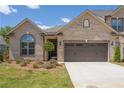 Beautiful brick home showcasing a two-car garage, manicured landscaping, and a welcoming entrance at 1041 Bonanza Ln # 37, Mebane, NC 27302