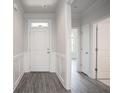 Inviting foyer featuring gray wood-look flooring, white trim, and a charming front door at 1041 Bonanza Ln # 37, Mebane, NC 27302