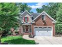 Charming home featuring a two-car garage, beautiful lawn and manicured shrubbery and trees at 111 Ferncroft Ct, Cary, NC 27519