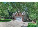 Well-maintained home features a two-car garage, long drive and lush surrounding trees at 111 Ferncroft Ct, Cary, NC 27519