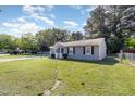 Side view of a cozy, single-story home with a spacious green lawn and mature trees at 1110 Allgood St, Durham, NC 27704