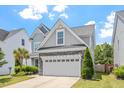 Charming two-story home with a two car garage, stone accents, manicured lawn, and mature landscaping at 1161 Tulip Poplar Rd, Fuquay Varina, NC 27526