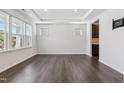 Spacious living room with wood floors, a tray ceiling, and lots of natural light from large windows at 1177 Sun Springs Rd, Wake Forest, NC 27587