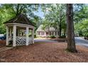 Exterior view of the home with cedar shake roof with red shutters and a gazebo nearby at 119 Palace Grn, Cary, NC 27518