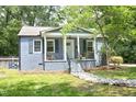 Quaint single Gathering home with a covered front porch, stone pathway, fresh grass and mature trees at 120 Pine St, Carrboro, NC 27510