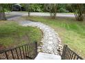 Stone and concrete walkway in the front yard with a black railing and stone accents at 120 Pine St, Carrboro, NC 27510