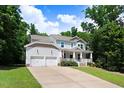 Charming two-story home with a covered front porch, a two-car garage, and a well-manicured lawn at 1304 Double Oak Ln, Willow Springs, NC 27592