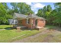 Classic brick house with a cozy front porch and a well-kept lawn, perfect for Gathering living at 1411 Hudson Ave, Durham, NC 27705