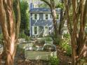 Two-story home with garden beds and lush trees surrounding, offering a serene outdoor living space at 1605 Valley Run, Durham, NC 27707