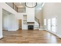 Bright, open living room features a fireplace, two story foyer and staircase with wooden floors at 162 Farmstead Ct, Wendell, NC 27591