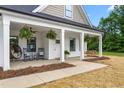 Inviting covered porch with hanging ferns, rocking chairs, and a swing for relaxing outdoors at 1711 Memory Ln, Burlington, NC 27217