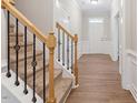 Inviting entryway boasts wood floors, white trim, and a staircase at 202 Verrazano Pl, Clayton, NC 27520