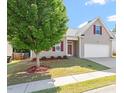 Charming home with a well-manicured lawn, complemented by vibrant red shutters, enhancing its curb appeal at 202 Verrazano Pl, Clayton, NC 27520