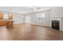 Open-concept living room with fireplace, ceiling fan, and hardwood floors at 202 Verrazano Pl, Clayton, NC 27520