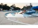 Community pool with water slides and various water features for a fun Gathering recreation on a sunny day at 202 Verrazano Pl, Clayton, NC 27520