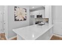 This open kitchen features white cabinets, stainless appliances, light backsplash, and a large island at 2040 Persimmon Ridge Dr, Raleigh, NC 27604