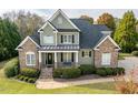 Charming home featuring a stone and siding facade, inviting front porch, and well-manicured lawn at 2100 Stone Pasture Rd, Fuquay Varina, NC 27526