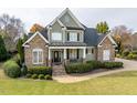 Charming home featuring a stone and siding facade, inviting front porch, and well-manicured lawn at 2100 Stone Pasture Rd, Fuquay Varina, NC 27526